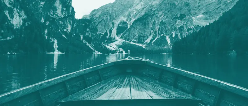 Wooden boat on a turquoise mountain lake, in PointFam teal